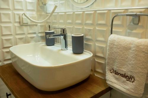 a white sink in a bathroom with a towel at Marrakesh Alaçatı in Ildır