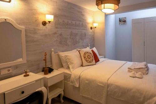 a bedroom with a bed and a desk and a tv at Marrakesh Alaçatı in Ildır