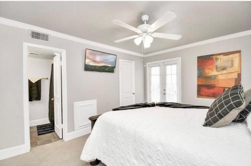 a bedroom with a white bed and a ceiling fan at Contemporary Master Queen Suite in Houston