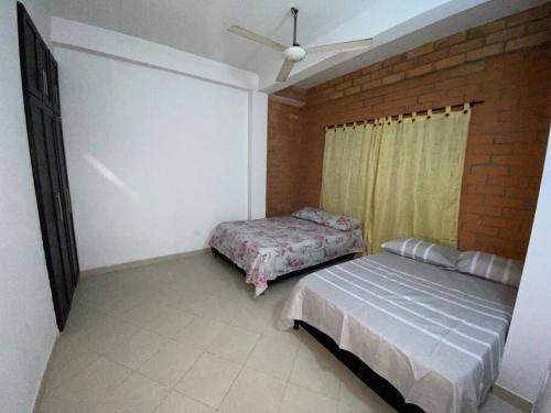 a bedroom with a bed and a brick wall at Apartamento acorde para una estadía tranquila. in Apartadó