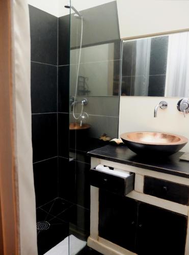 a bathroom with a sink and a glass shower at Family Secrets Douro in Riba Douro