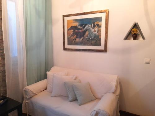 a white couch in a room with a painting on the wall at Ζoe Studios in Kýthira