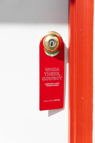 a red door tag hanging on a white wall at Mesa Verde Motel in Mancos