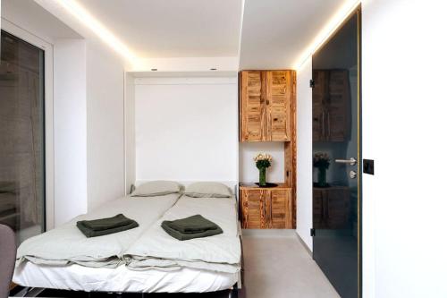 1 dormitorio con 1 cama con toallas en Small but WOW! Studio with pool @ the central lake, en Crans-Montana