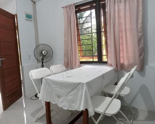 una mesa y sillas blancas en una habitación con ventana en Homestay dekat Darussalam & Ulee Kareng en Lamnyong