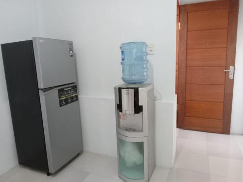 a water cooler sitting next to a refrigerator at Bak Trieng Homestay - depan Mushalla Baitul Muttaqien BUPERTA in Lamnyong