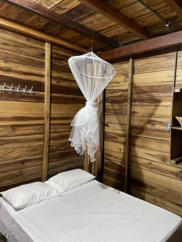 a bed in a room with a net at the mompe beach hostal in La Poza