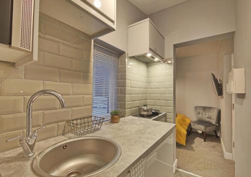 una cucina con lavandino e sedia in una stanza di Cosy Holiday Home in Hazel Grove - Self Catering Apartment 1 a Hazel Grove