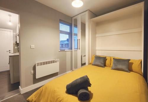 a bedroom with a yellow bed and a window at Cosy Holiday Studio in Hazel Grove - Self Catering Apartment 1 in Hazel Grove