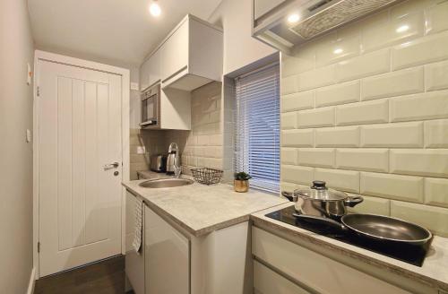 a small kitchen with a sink and two sinks at Cosy Holiday Home in Hazel Grove - Self Catering Apartment 1 in Hazel Grove