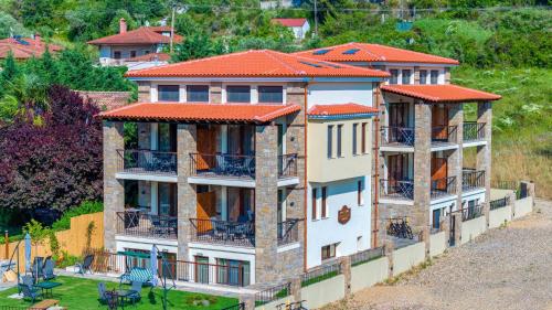 un grande edificio con tetti rossi su una collina di Penelope Luxury Suites a Fourka