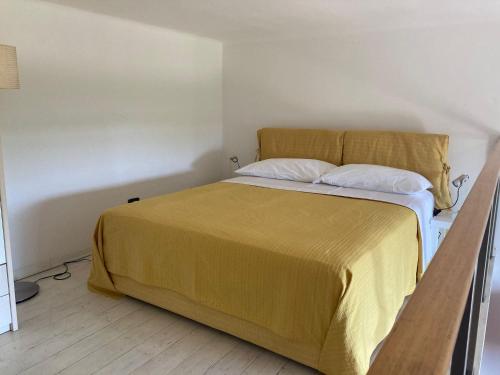 a bedroom with a bed with a yellow bedspread at Scoglio della Regina, NUOVO, fronte mare, vicino al porto in Livorno