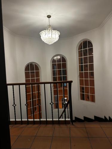a room with three windows and a chandelier at Hotel Artistico in Bogotá