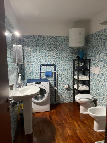 a bathroom with a washing machine and a sink at Scoglio della Regina, NUOVO, fronte mare, vicino al porto in Livorno