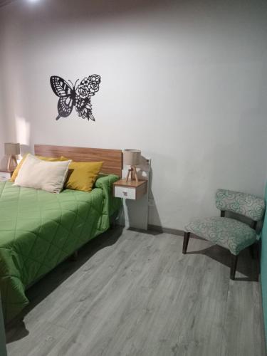 1 dormitorio con cama y calcomanía de mariposa en la pared en Casa pura vida en General Roca