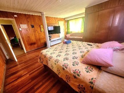 1 dormitorio con 1 cama con colcha de flores en Eliodoro Yañez Casa o chalet, en Valdivia