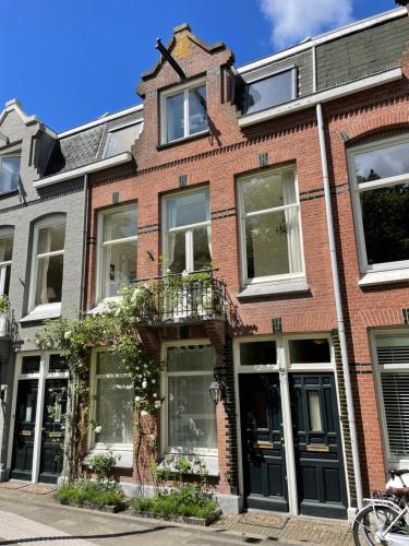 a red brick building with a balcony on a street at Canal View Stay Amsterdam in Amsterdam