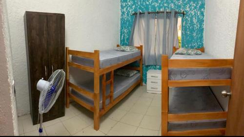 帕爾克德爾普拉塔的住宿－Casa as palmas，客房设有两张双层床和风扇。