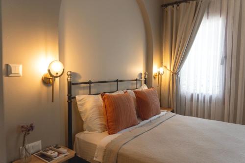 a bedroom with a bed with two pillows and a window at Kapya Cunda in Ayvalık