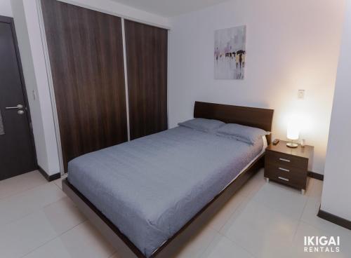 a bedroom with a large bed and a night stand at Contempo Loft Apart 11 in Curridabat