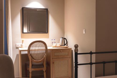 a bedroom with a desk with a chair and a bed at Kapya Cunda in Ayvalık