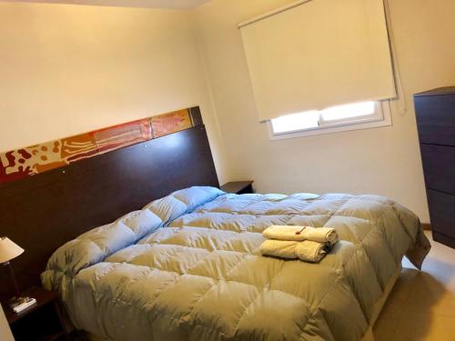 1 dormitorio con 1 cama con 2 toallas en Departamentos amoblados de Jardines de Libertador en San Juan