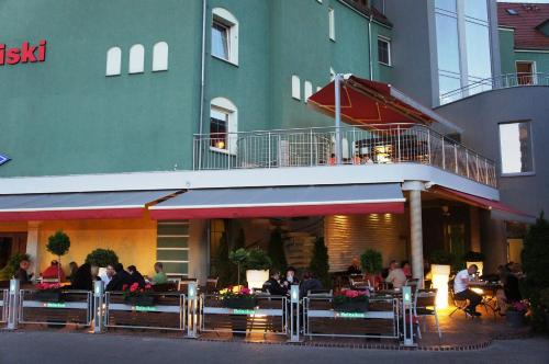 a group of people sitting outside of a restaurant at Hotel Kaliski in Słubice