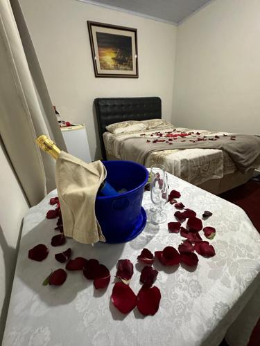 a room with roses on a table with a bed at Pousada Recanto dos Pássaros in Lindóia