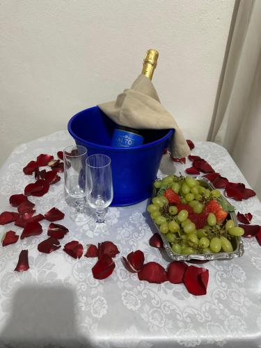 a table with a bottle of wine and a plate of fruit at Pousada Recanto dos Pássaros in Lindóia