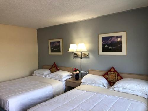 a hotel room with two beds and two lamps at A1 Choice Inn in Mount Shasta