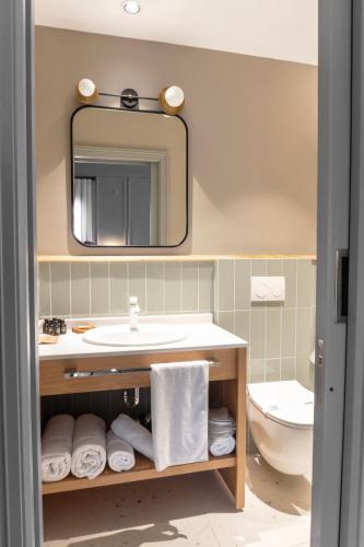 a bathroom with a sink and a mirror and a toilet at Kapya Cunda in Ayvalık