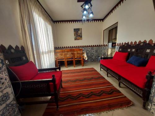 a living room with two red couches and a rug at Babel Ain Sokhna in Ain Sokhna