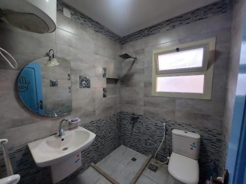 uma casa de banho com um lavatório, um WC e um espelho. em Babel Ain Sokhna em Ain Sokhna