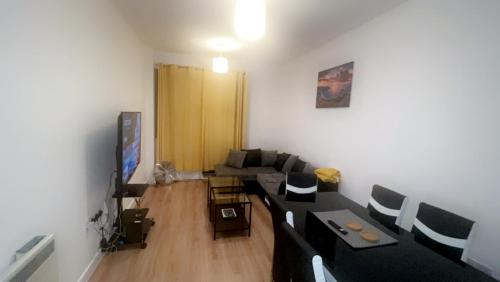 a living room with a couch and a tv at Modern City Centre Executive Flat in Southend-on-Sea