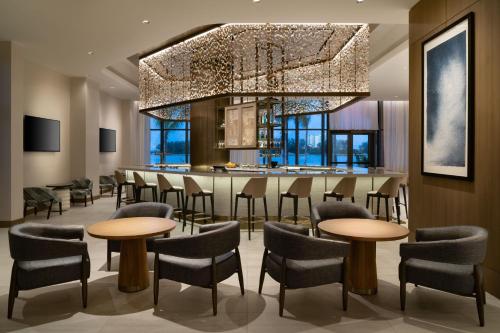 a dining room with tables and chairs and a chandelier at JW Marriott Clearwater Beach Resort & Spa in Clearwater Beach