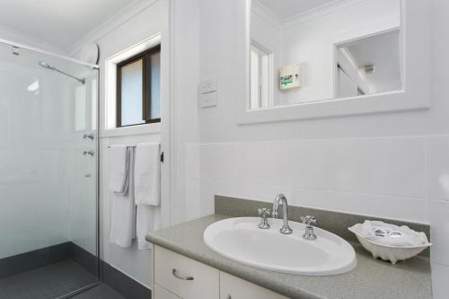 a white bathroom with a sink and a shower at Victor Harbor Holiday Park in Victor Harbor