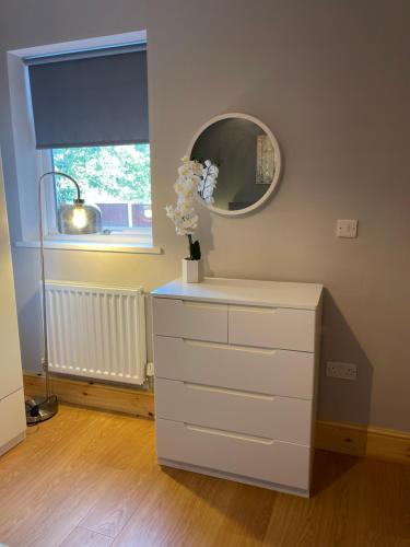 un tocador blanco con un espejo encima en West Midlands-2 Double Bed Room Apartment, en Dudley