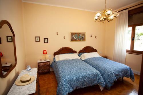1 dormitorio con 2 camas, mantas azules y espejo en Sea Breeze and beautiful views!, en Muros de Nalón