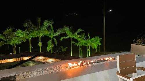 a backyard with a fire pit and palm trees at night at Aguas Claras Luxury Hospedaje in Filandia