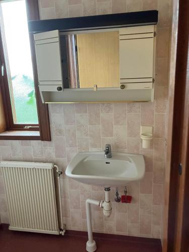 łazienka z umywalką, lustrem i grzejnikiem w obiekcie Vetlandavägen 37 B w mieście Målilla