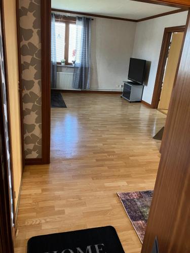 a living room with a wooden floor and a television at Vetlandavägen 37 B in Målilla