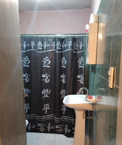 a bathroom with a shower curtain with asian writing on it at Doña Chicha in Tinogasta