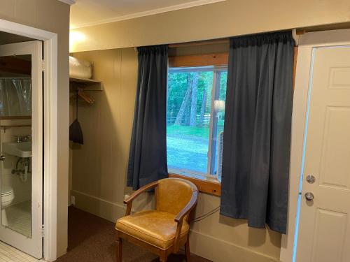 a chair sitting in front of a window at Northern Lights Lodge in Stowe