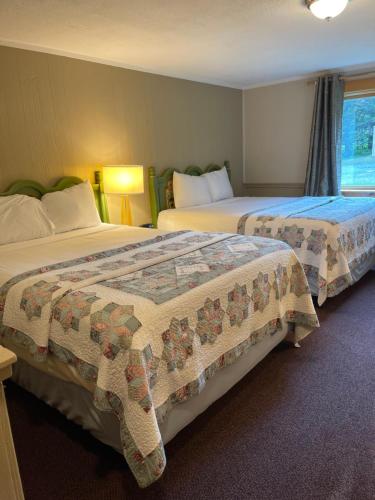 a hotel room with two beds and a window at Northern Lights Lodge in Stowe