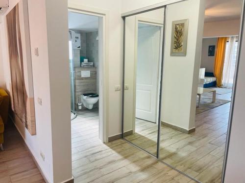 a hallway with a mirror and a bathroom with a toilet at Rohan Studio One in Mamaia Sat/Năvodari