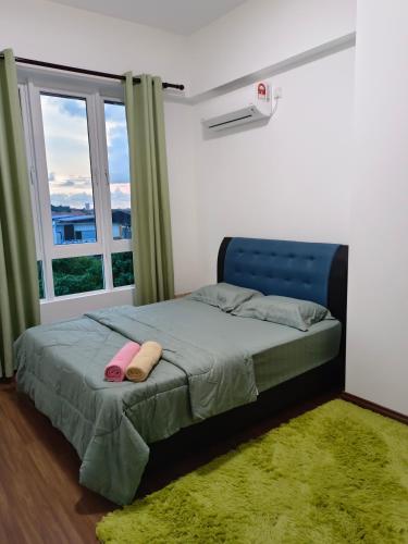 a bedroom with a bed with a blue headboard and a window at Nasuha Homestay in Sandakan