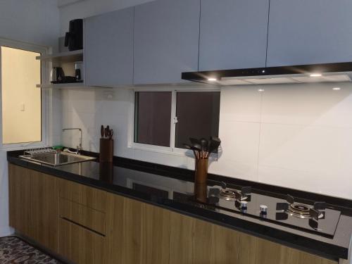a kitchen with a sink and a counter top at Nasuha Homestay in Sandakan