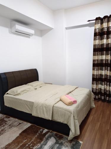 a bedroom with a bed and a window with a curtain at Nasuha Homestay in Sandakan