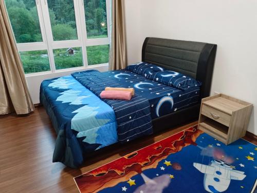a bedroom with a bed with a blue comforter at Nasuha Homestay in Sandakan
