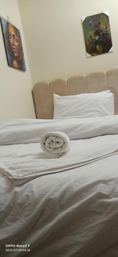 two beds with white sheets and a towel on them at Crystal pyramid inn in Cairo